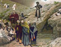 Johannes de doper predikt staand op een rots op de oever van de Jordaan